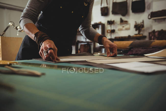 Mid-section of craftswoman arranging leather piece in workshop — Stock Photo