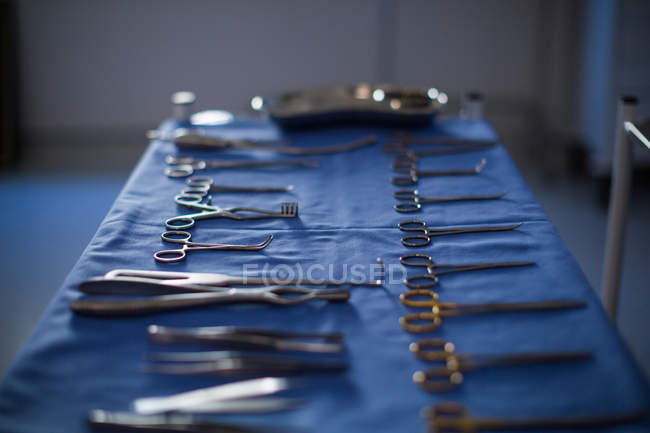 Instrumentos quirúrgicos mantenidos sobre una mesa en quirófano en el hospital - foto de stock