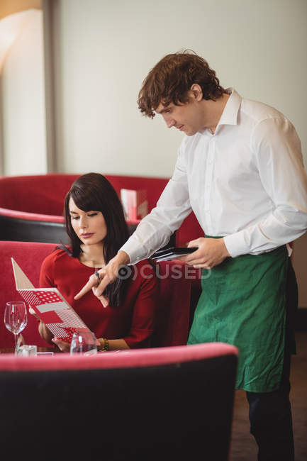 Официант принимает заказ от женщины в ресторане — стоковое фото