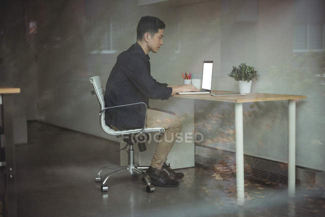 Business executive working on laptop in office — Stock Photo