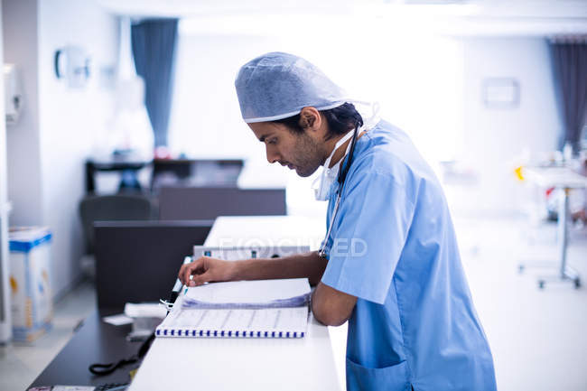 Surgeon reading medical report at hospital — Stock Photo