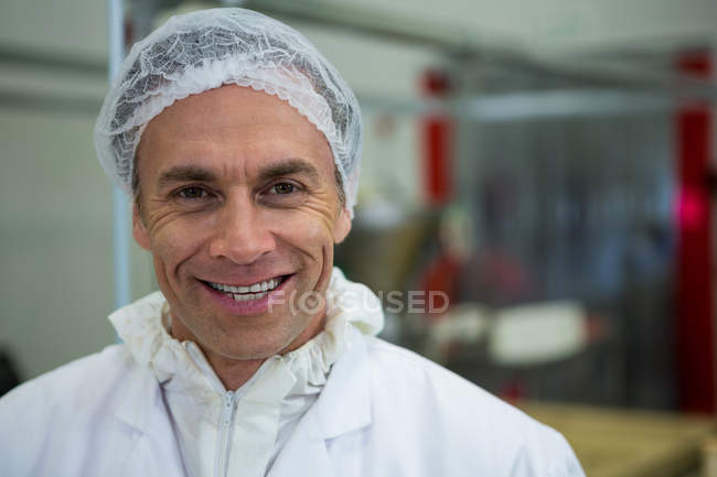 Porträt eines Metzgers, der in Fleischfabrik lächelt — Stockfoto