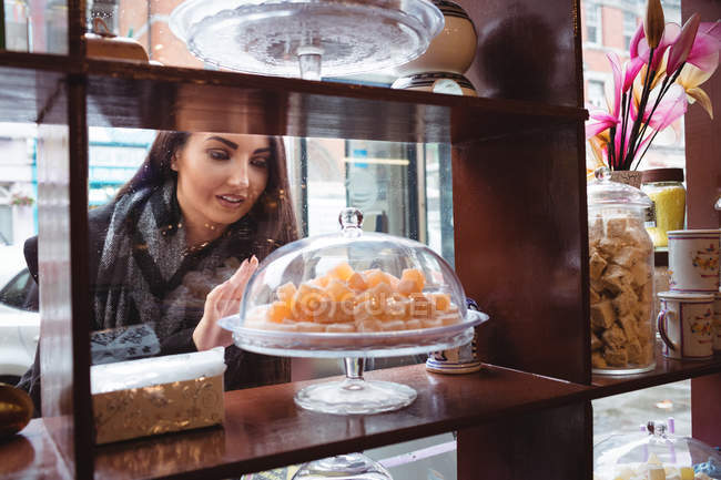 Hermosa mujer mirando dulces turcos en la tienda - foto de stock