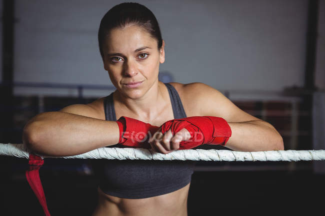 Уверенная женщина-боксер надеется на боксерское кольцо в фитнес-студии — стоковое фото