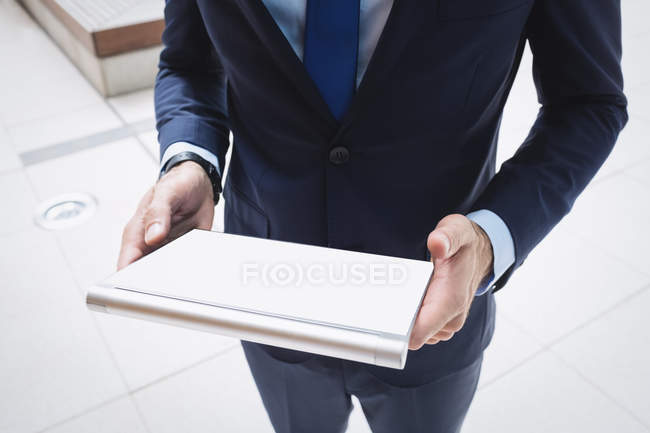 Image recadrée d'un homme d'affaires utilisant une tablette numérique à l'extérieur d'un immeuble de bureaux — Photo de stock