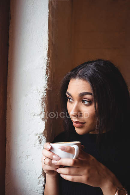 Donna premurosa che beve una tazza di caffè nel caffè — Foto stock