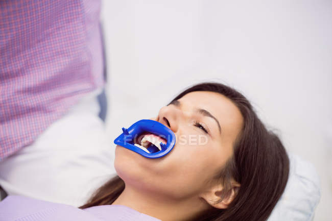Female patient receiving teeth treatment at dental clinic — Stock Photo