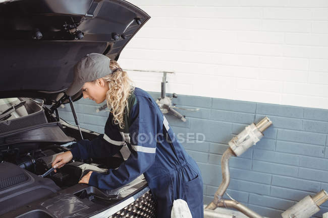 Mechanikerin wartet Auto in Werkstatt — Stockfoto