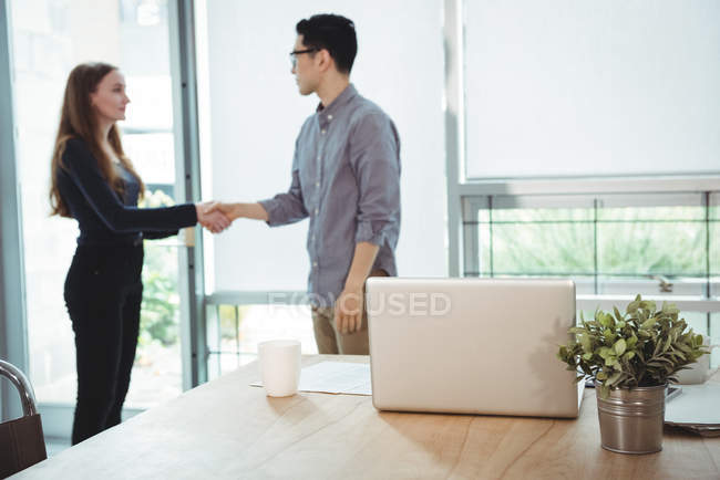 Executivos de negócios apertando a mão uns dos outros no escritório — Fotografia de Stock