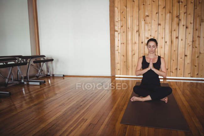 Woman performing yoga in fitness studio — Stock Photo