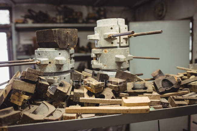 Moldes de metal e madeira para sopro de vidro dispostos na prateleira na fábrica de sopro de vidro — Fotografia de Stock