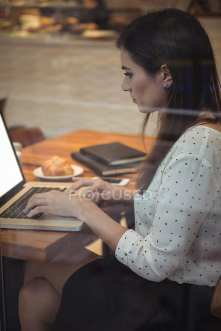 Belle femme d'affaires utilisant un ordinateur portable dans le café — Photo de stock