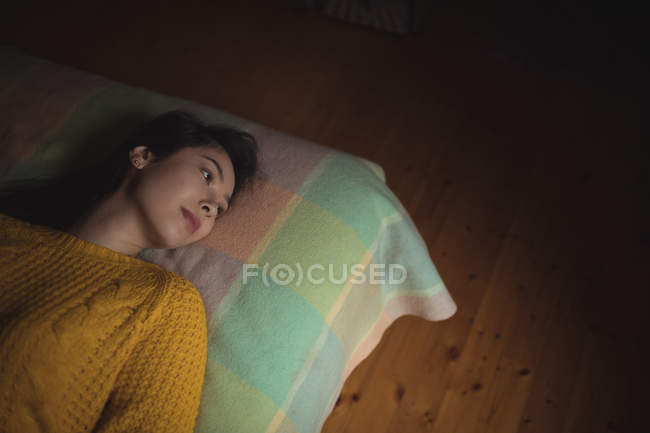 Продумана жінка лежить на ліжку вдома — стокове фото
