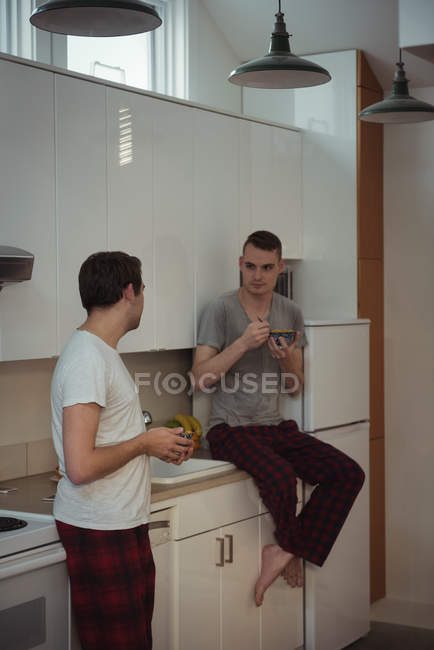 Gay casal tendo pequeno-almoço no cozinha no casa — Fotografia de Stock