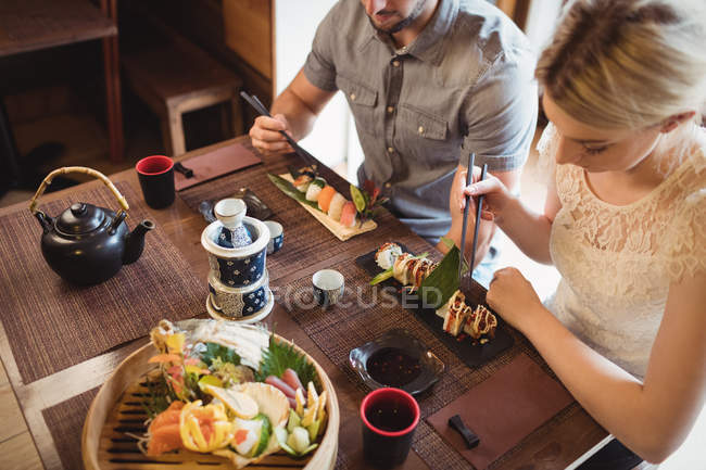 Vista de alto ângulo de casal tendo sushi no restaurante — Fotografia de Stock