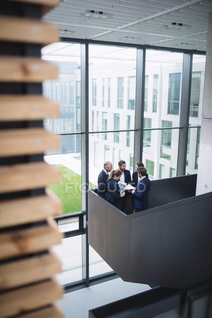 Группа деловых людей, обсуждающих у лестницы в офисе — стоковое фото