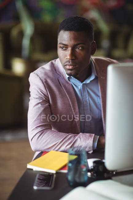 Pensativo hombre de negocios mirando hacia otro lado en la oficina - foto de stock