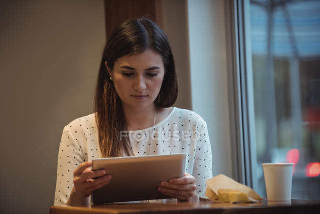 Mulher de negócios bonita usando tablet digital no café — Fotografia de Stock