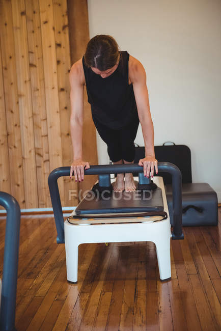 Femme pratiquant pilates sur réformateur dans le studio de fitness — Photo de stock