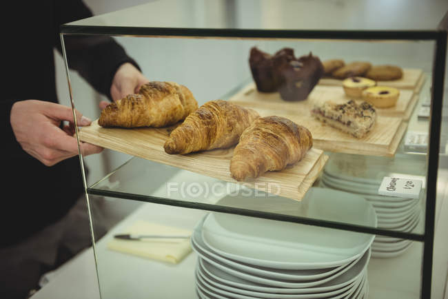 Primo piano delle mani maschili che rimuovono il vassoio dei croissant — Foto stock