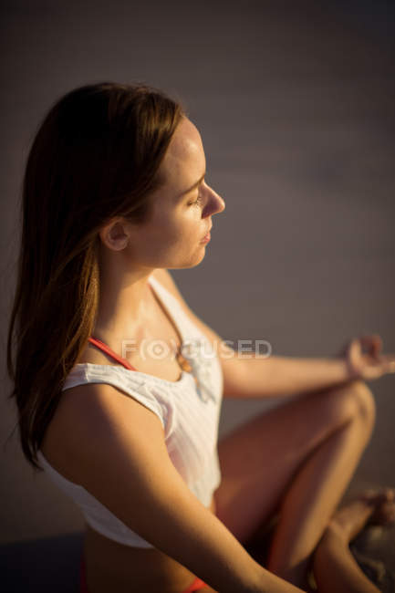 Schöne Frau, die an einem sonnigen Tag Yoga am Strand macht — Stockfoto