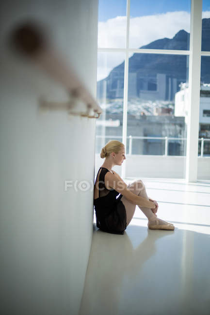 Ballerina depressa seduta contro il muro in studio — Foto stock
