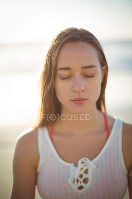 Beautiful woman performing yoga on beach on a sunny day — Stock Photo