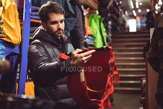 Homme sélectionnant des vêtements dans un magasin de vêtements — Photo de stock