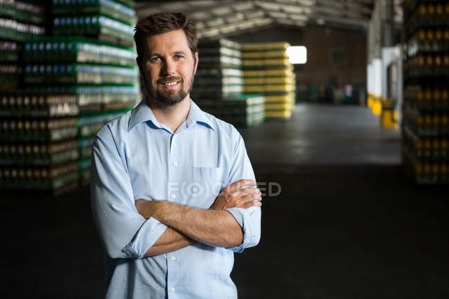 Retrato de un trabajador varón confiado parado en el almacén - foto de stock