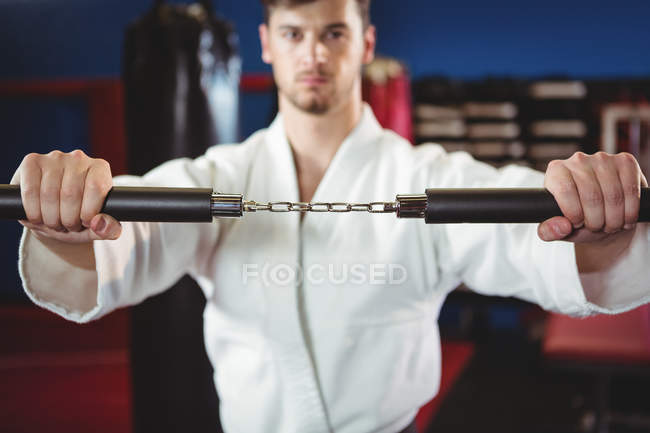 Karate-Spieler übt mit Nunchaku im Fitnessstudio — Stockfoto