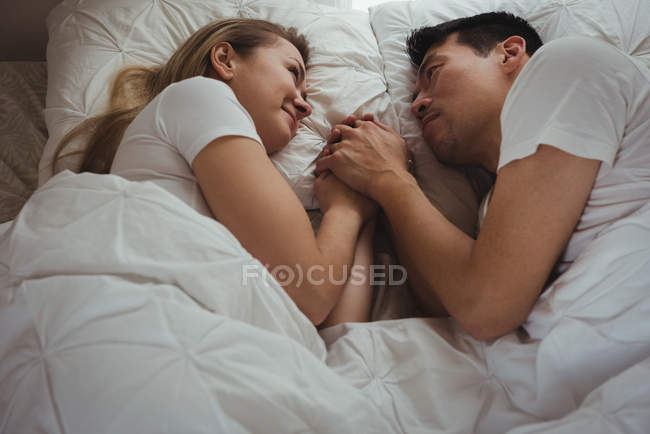 Casal romântico deitado na cama no quarto — Fotografia de Stock