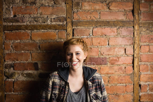 Портрет красивої жінки, що стоїть на цегляній стіні — стокове фото
