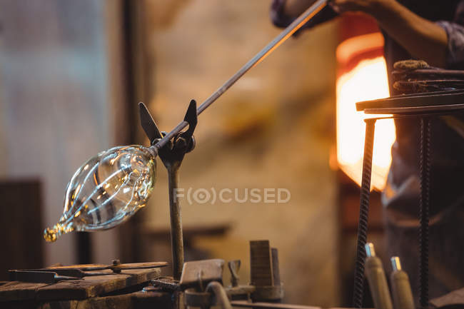 Primer plano del soplador de vidrio que forma un vidrio fundido en la fábrica de soplado de vidrio - foto de stock