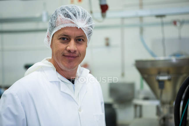 Retrato del carnicero sonriendo en la fábrica de carne - foto de stock