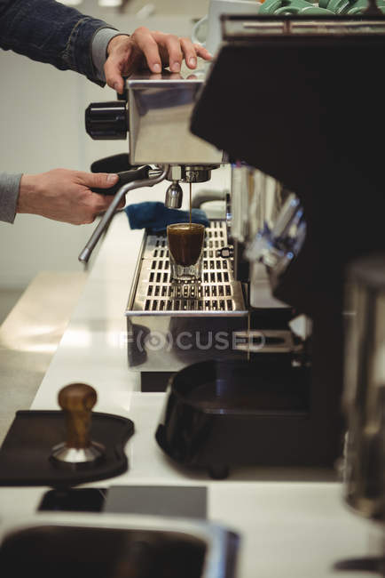 Mano del hombre preparando café en la máquina de café en la cafetería - foto de stock