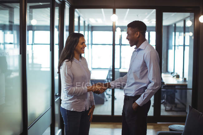 Empresario y un colega estrechando la mano en la oficina - foto de stock
