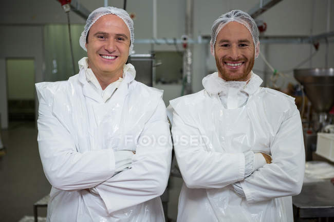 Portrait of butchers standing with arms crossed at meat factory — Stock Photo