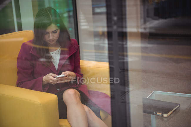 Красива бізнес-леді, використовуючи мобільний телефон в офісі — стокове фото