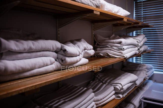 Mantas plegadas dispuestas en estante en el hospital - foto de stock