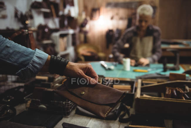 Craftswoman with hand holding wallet in workshop — Stock Photo