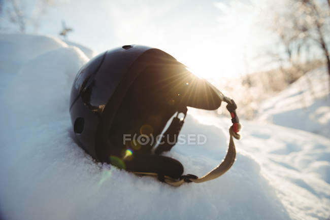 Ski helmet on snowy landscape against bright sunlight — Stock Photo