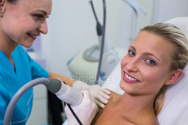 Woman receiving laser epilation treatment on body at beauty salon — Stock Photo