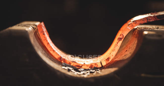 Nahaufnahme einer geschmiedeten, erhitzten Eisenstange in der Werkstatt — Stockfoto