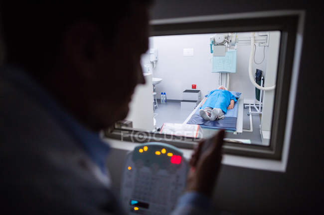 Doctor using x-ray unit control panel on patient in hospital — Stock Photo