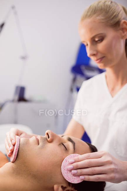 Paciente masculino que recibe masaje del médico en la clínica - foto de stock