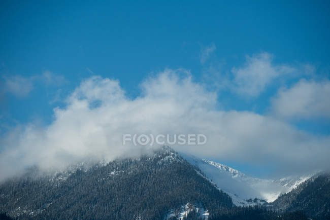 Vista majestosa da bela gama de montanhas nevadas contra o céu azul e as nuvens — Fotografia de Stock