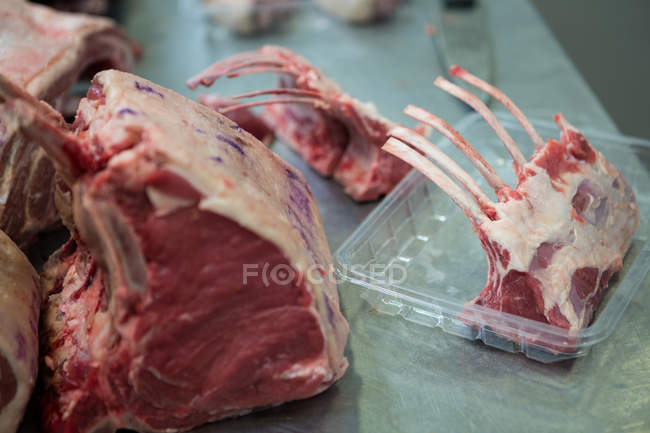 Raw meat on metallic table at meat factory — Stock Photo
