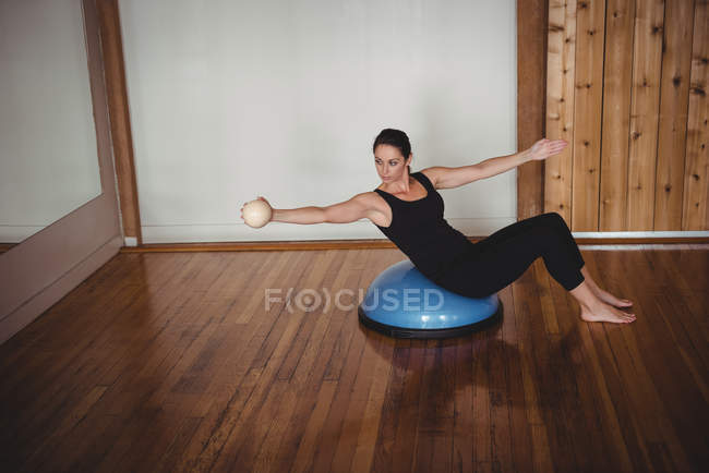 Жінка робить вправи на босу м'яч у фітнес-студії — стокове фото