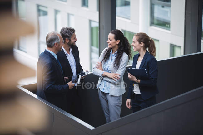 Group of business people having a discussion near staircase in office — Stock Photo