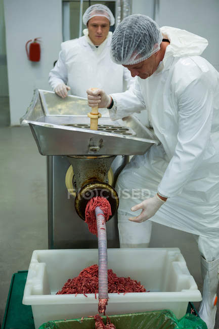 Macellai che utilizzano tritacarne presso la fabbrica di carne — Foto stock